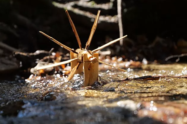 kleines Wasserrad aus Holz in einem Bach